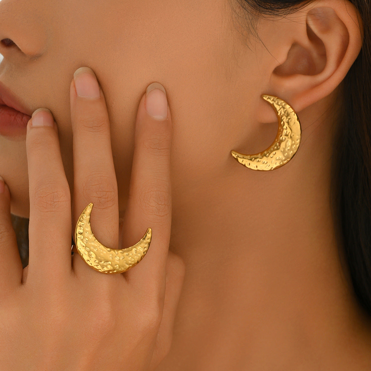 Model wearing gold-tone hammered crescent earrings